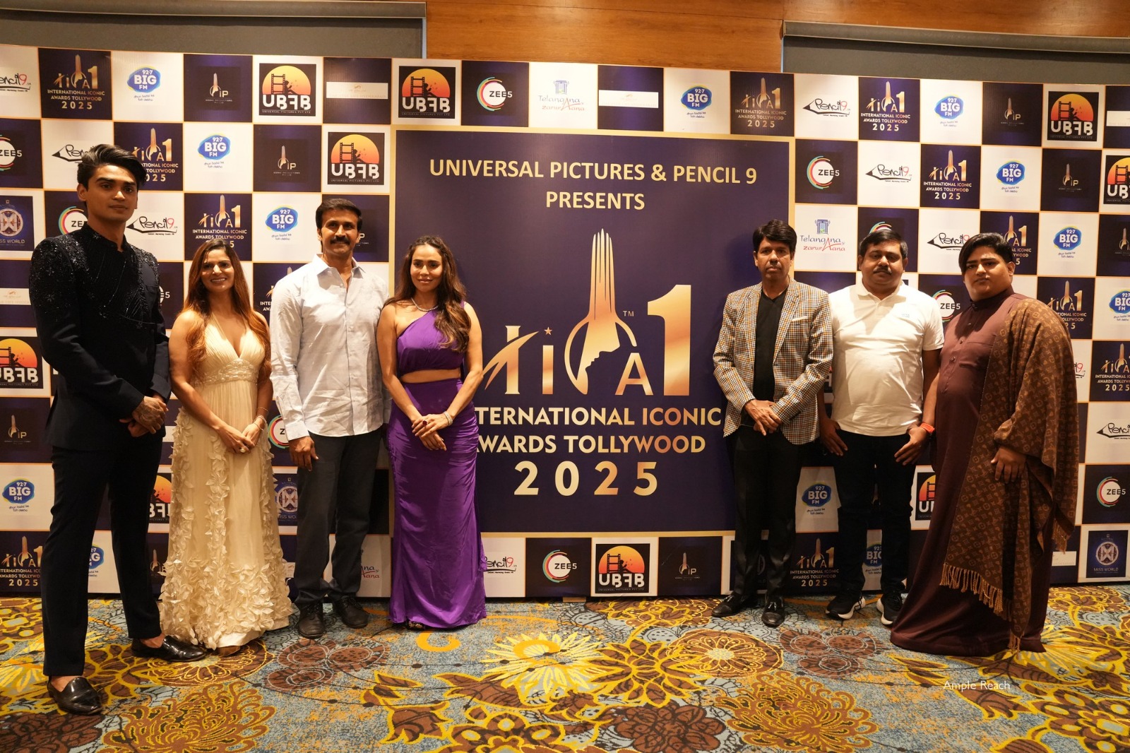 Celebrities and guests pose at the International Iconic Awards Tollywood 2025, presented by Universal Pictures and Pencil 9, in front of a branded backdrop.