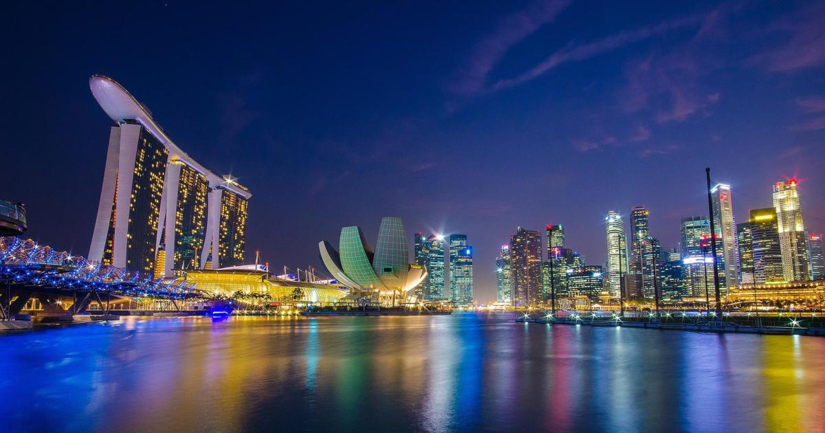 Singapore Marina Bay skyline at night featuring Marina Bay Sands, ArtScience Museum, and illuminated skyscrapers reflected in the bay