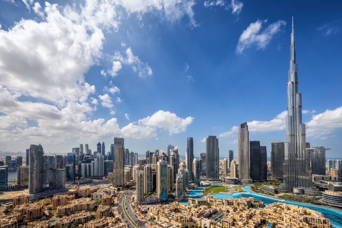 Panoramic view of Dubai skyline with Burj Khalifa and downtown skyscrapers under a bright blue sky