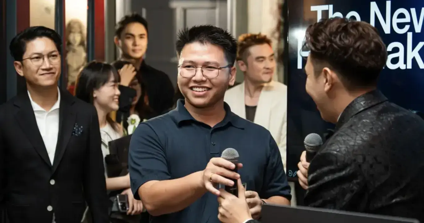 Entrepreneur speaking at networking event, holding microphone during live discussion with startup founders and business leaders.