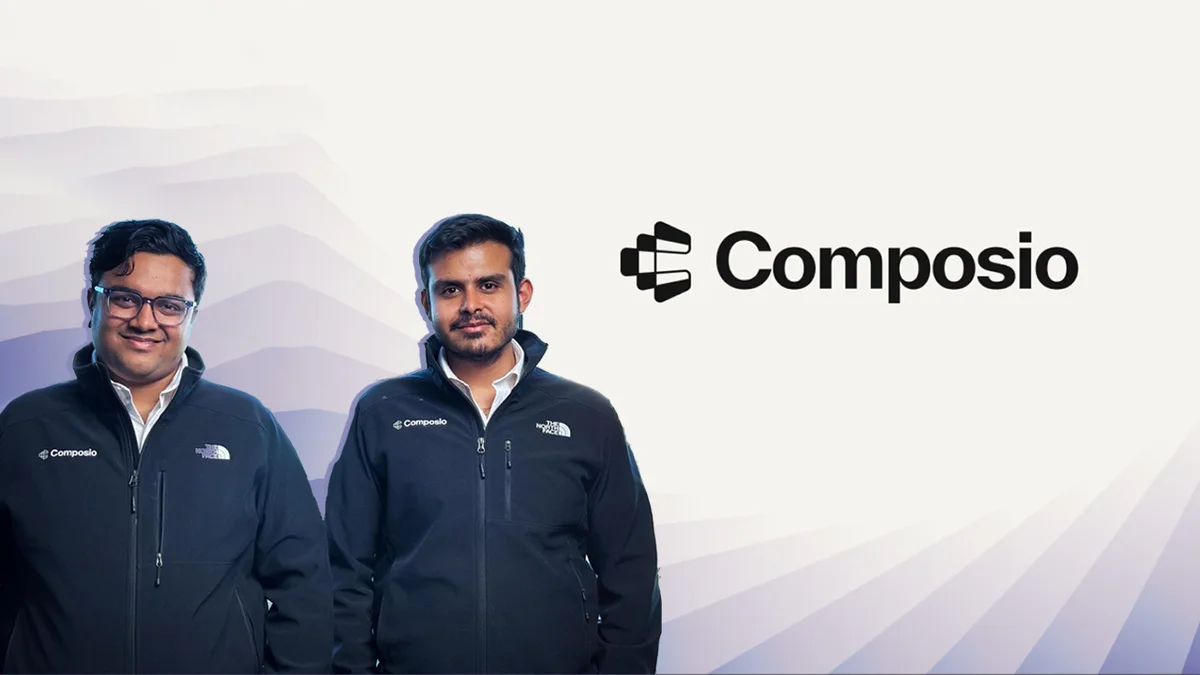 Founders of Composio pose in branded jackets beside the company logo, representing the India-based SaaS startup focused on API integration and developer productivity.