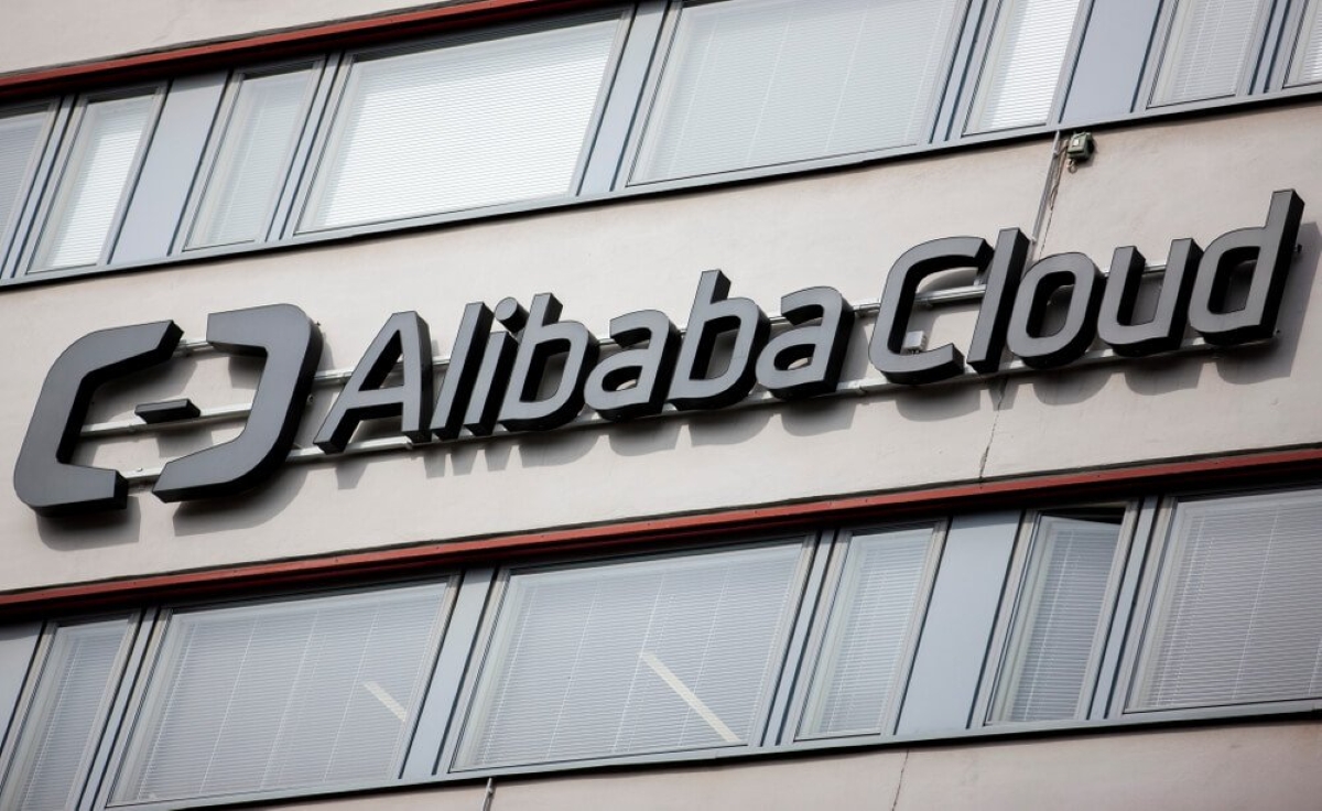 Alibaba Cloud company logo mounted on the exterior of a modern office building, showcasing the cloud computing brand's corporate presence.