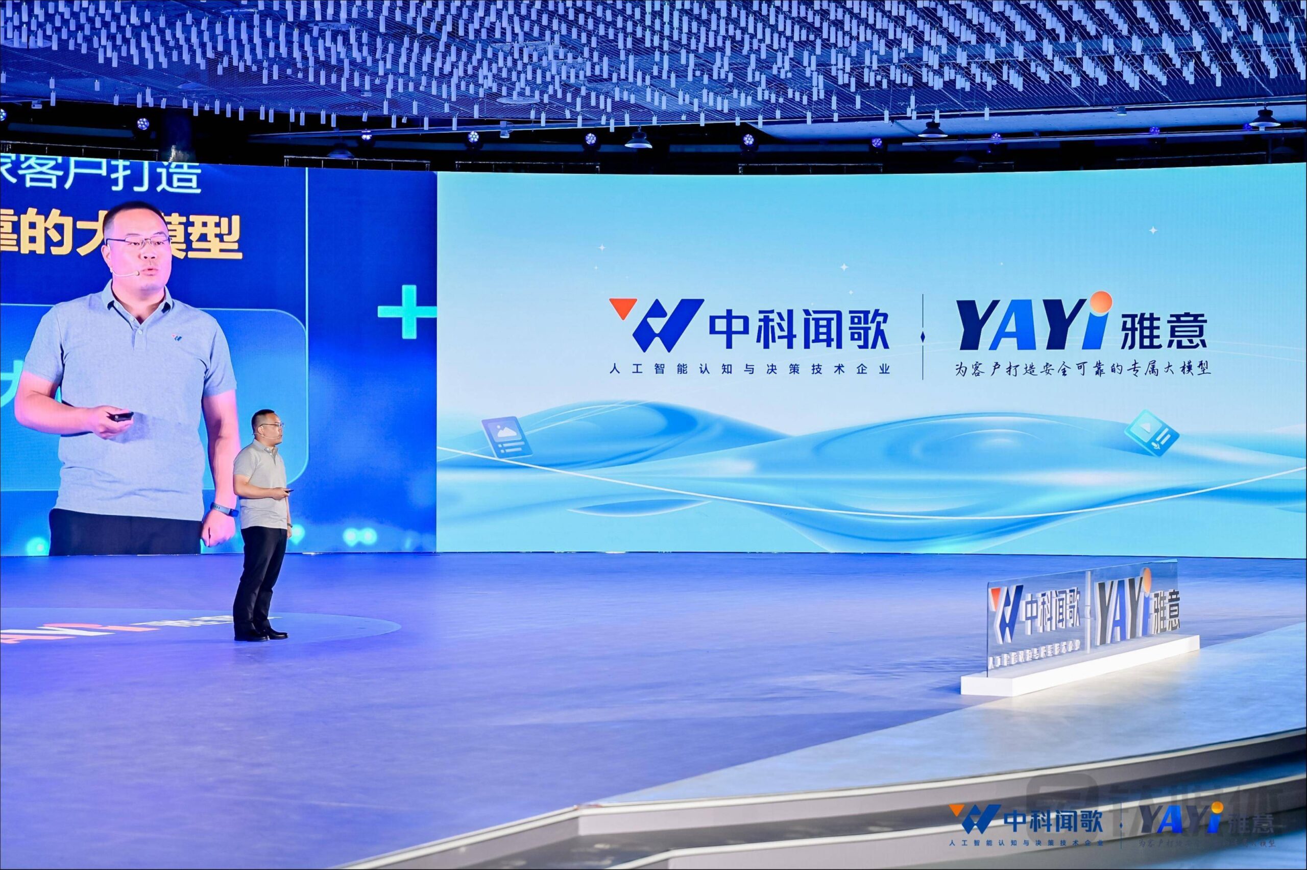 A speaker presents on stage at a Chinese AI conference with large digital screens displaying the logos of Zhongke Wenge and Yayi, highlighting artificial intelligence and decision-making technology.