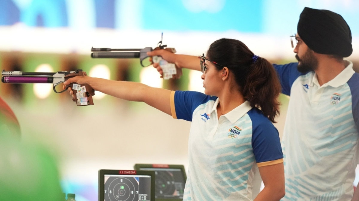 Indian mixed team shooters aiming during a precision event, wearing official India Olympic uniforms, showcasing focus, discipline, and national representation in competitive shooting.