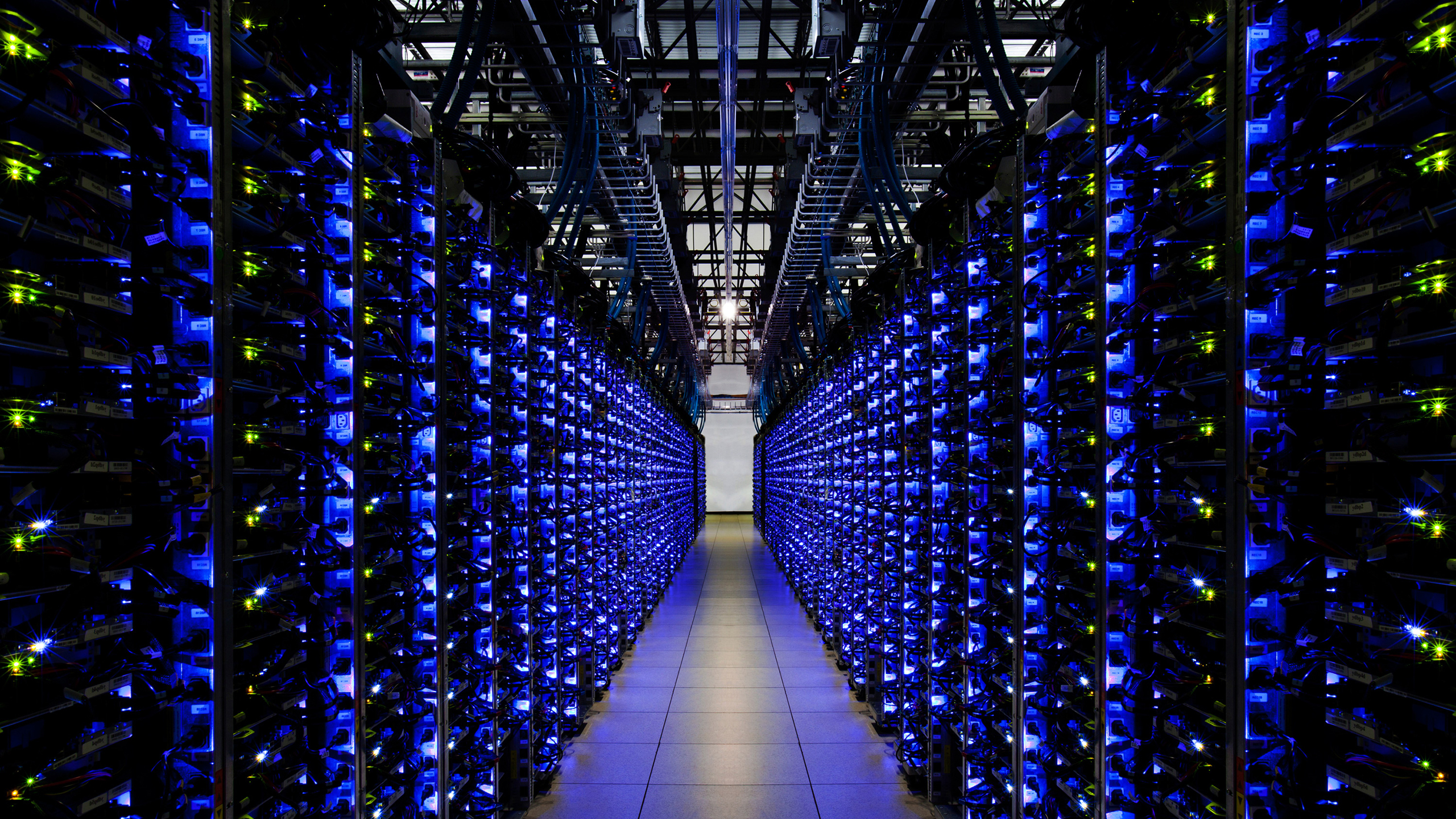 Interior of a modern data center with rows of illuminated blue server racks, showcasing advanced cloud computing and AI infrastructure.