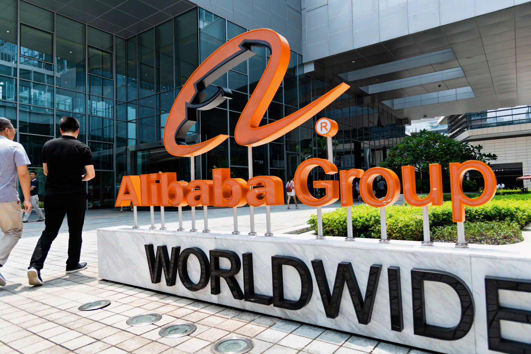 Alibaba Group headquarters with prominent company logo in front of a modern glass office building in China.