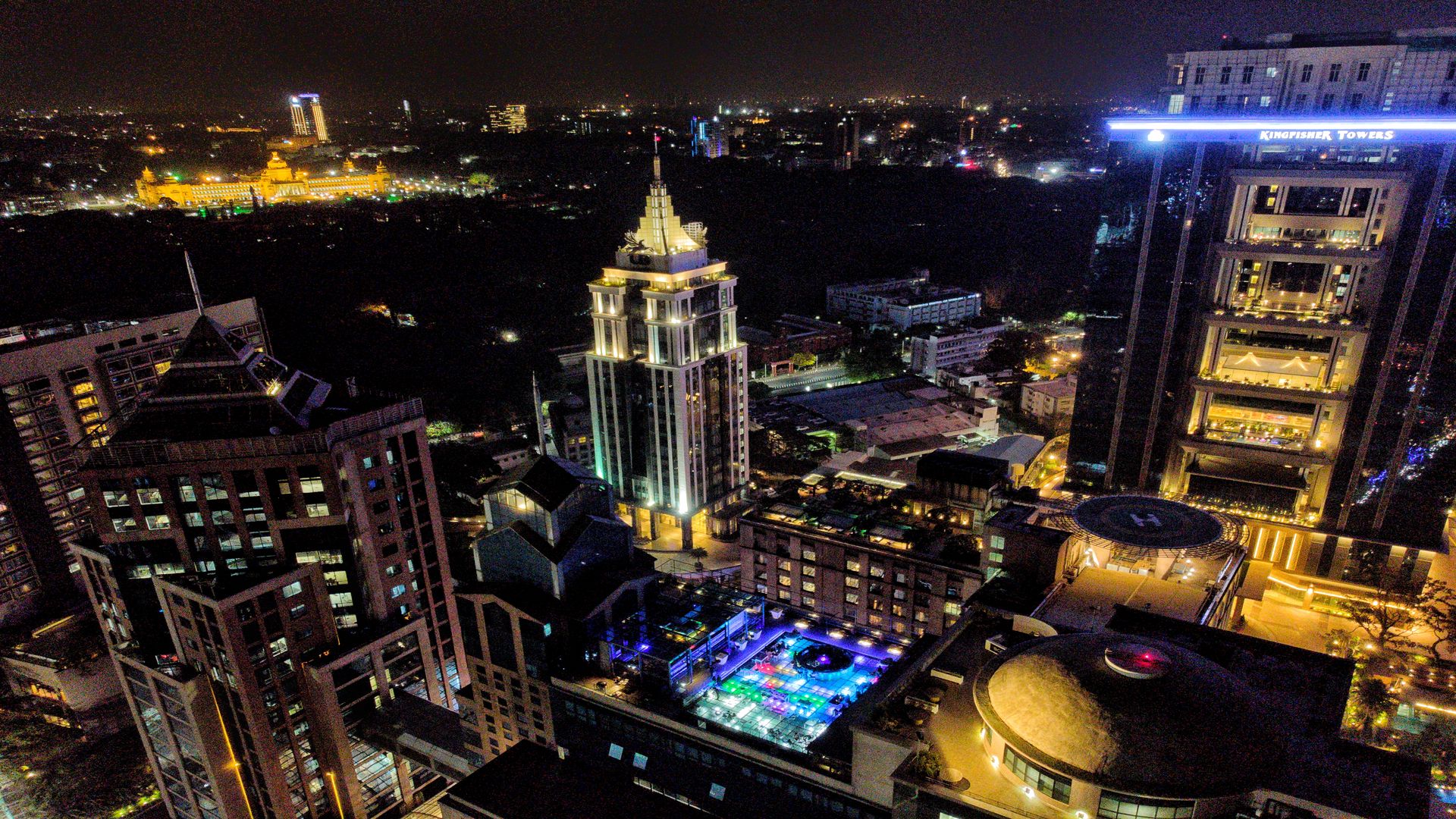 Aerial night view of Bengaluru’s central business district with Kingfisher Towers and the illuminated Vidhana Soudha in the background.