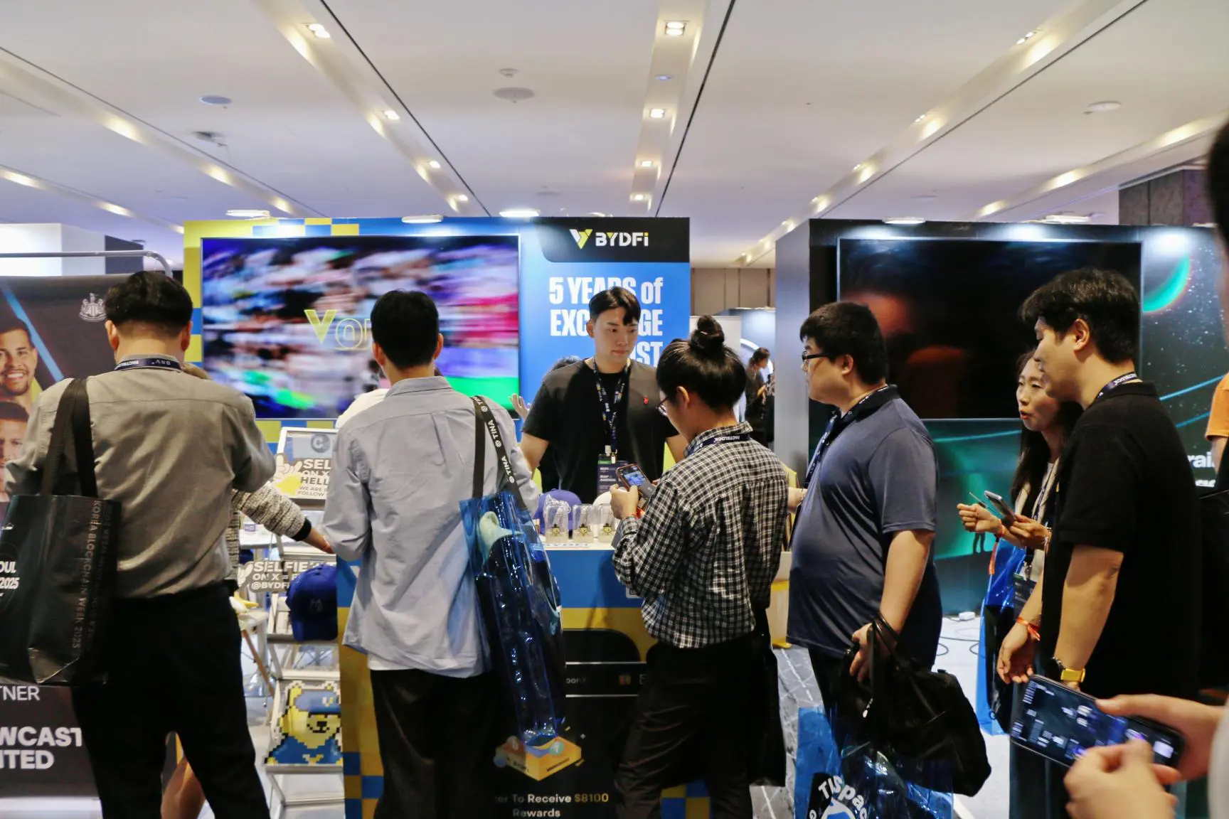 Attendees gather at the BYDFi booth during Korea Blockchain Week 2025 (KBW2025), engaging with crypto exchange representatives and exploring digital asset products at a blockchain industry exhibition in Seoul.