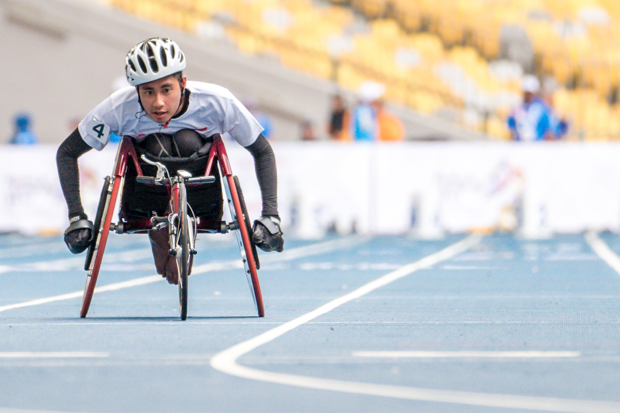 Para-athlete competing in a wheelchair racing event on a blue athletics track, highlighting adaptive sports performance and inclusivity in international athletics competitions.