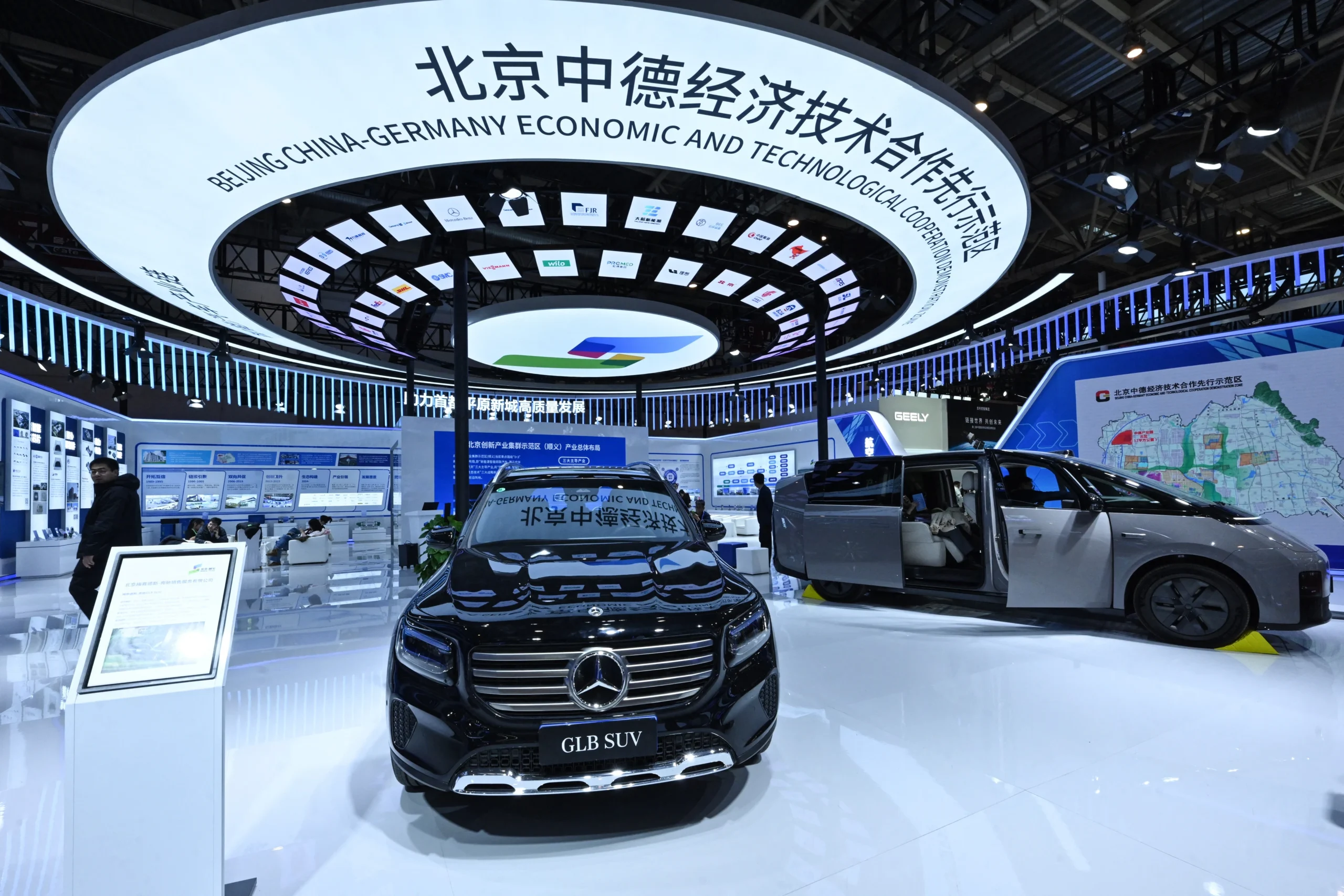 Beijing China-Germany Economic and Technological Cooperation exhibition booth featuring Mercedes-Benz GLB SUV and electric vehicles at international trade expo.