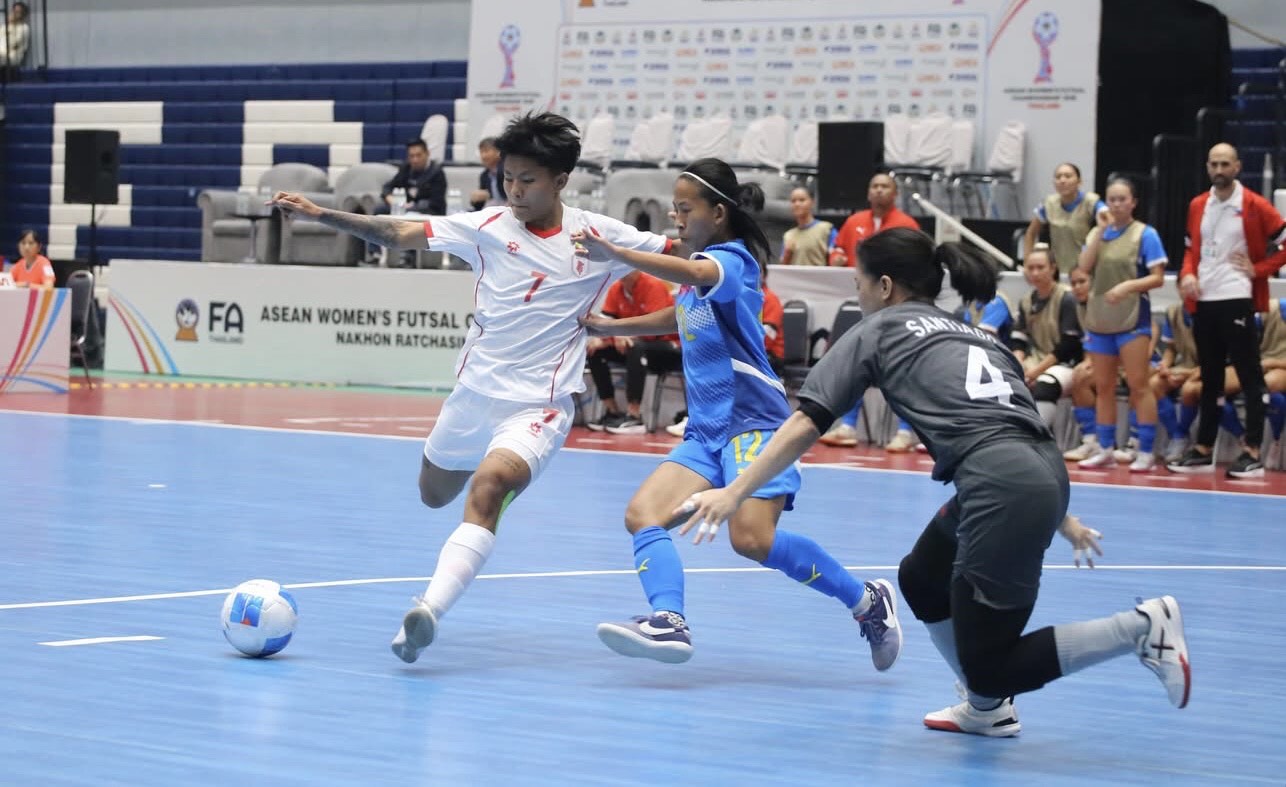 ASEAN Women’s Futsal Championship match in Nakhon Ratchasima as players compete intensely for ball possession during regional tournament.