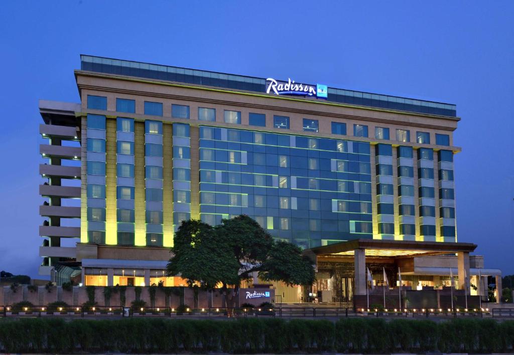 Radisson Blu hotel exterior at dusk, showcasing modern luxury hospitality property with illuminated glass façade and premium accommodation branding.